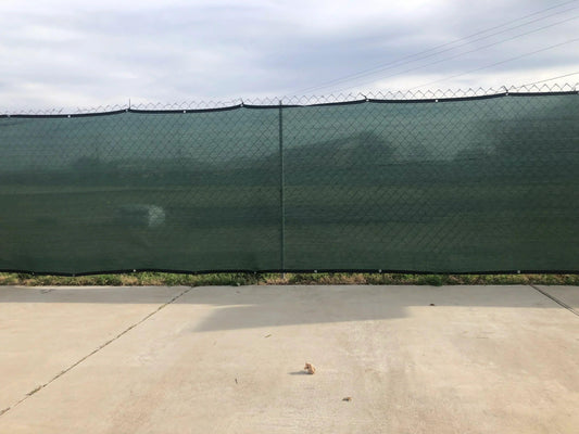 Green 4' x 50' 90% privacy fence mesh tarp providing wind filtering coverage