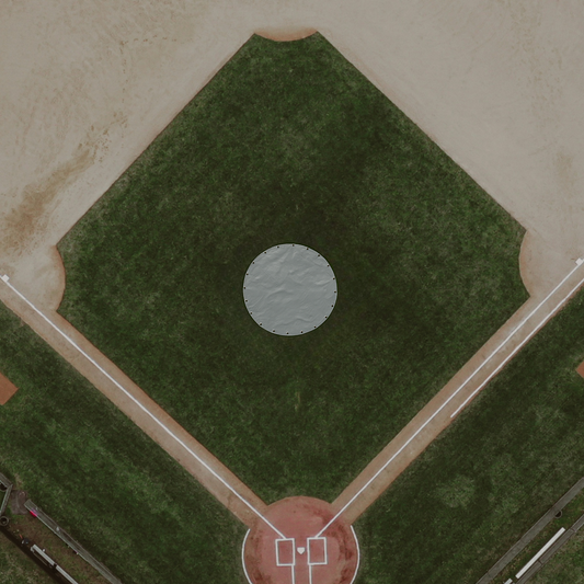 Aerial view of a baseball field with green grass and 19ft round mound tarp cover.