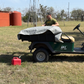 Gray waterproof canvas tarp covering utility cart bed in outdoor setting; provides durable protection for tools, gear, and equipment.