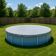 Round above-ground pool with cover on grassy area with trees in the background