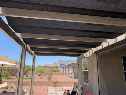 Black 14' x 20' 86% super shade mesh tarp installed above a deck area