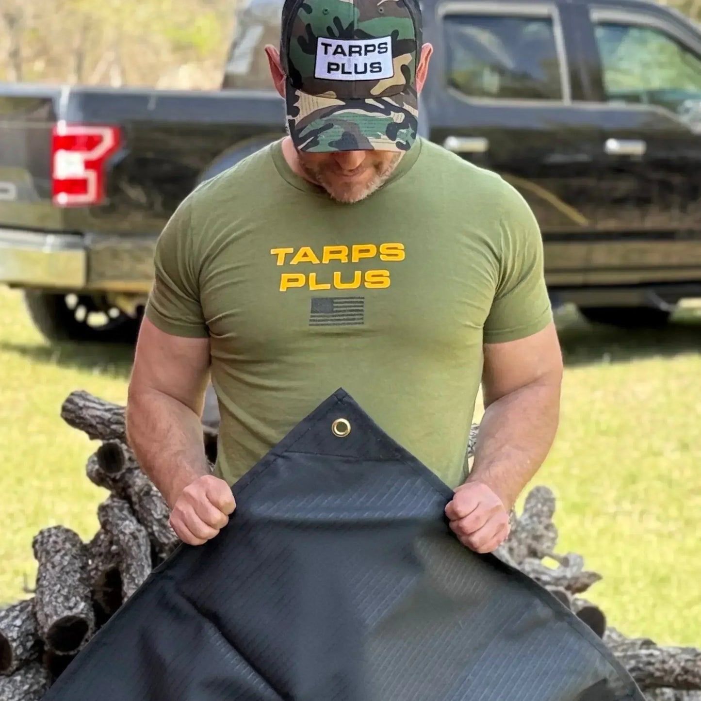 Black 5' x 7' waterproof canvas tarp showcased during outdoor utility presentation