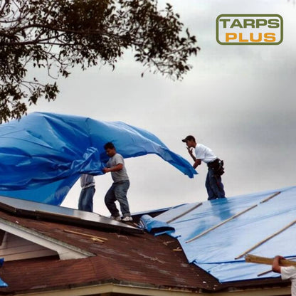 Blue hurricane tarp being installed as roof protection against severe weather conditions