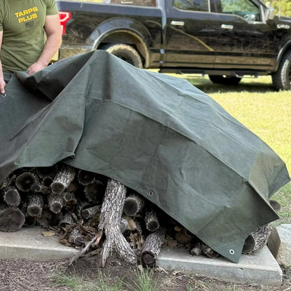 Olive Drab 8' x 12' canvas tarp shielding stacked firewood from weather exposure