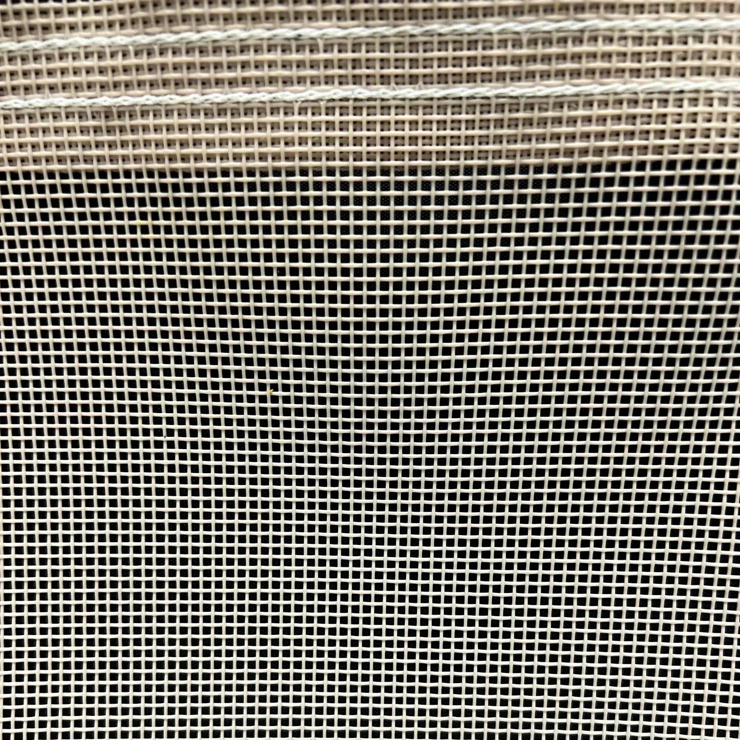 Tan 12' x 16' vinyl mesh tarp displaying dense mesh grid and durable border stitching