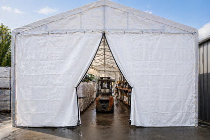White tarp tent with zipper door entrance used for warehouse storage showing forklift access through tarp opening