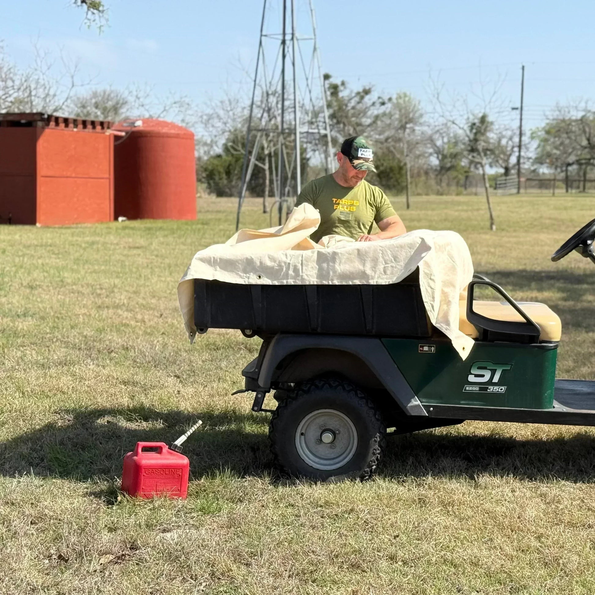 White 16' x 20' canvas tarp draped over outdoor utility equipment for protection
