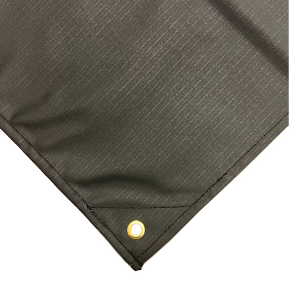 Close-up of black waterproof ripstop canvas tarp corner featuring reinforced stitching and a brass grommet; durable and ideal for heavy-duty outdoor use.