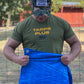 Man in a Tarps Plus shirt demonstrating the strength and flexibility of a blue poly tarp; ideal for light-duty outdoor coverage and protection.